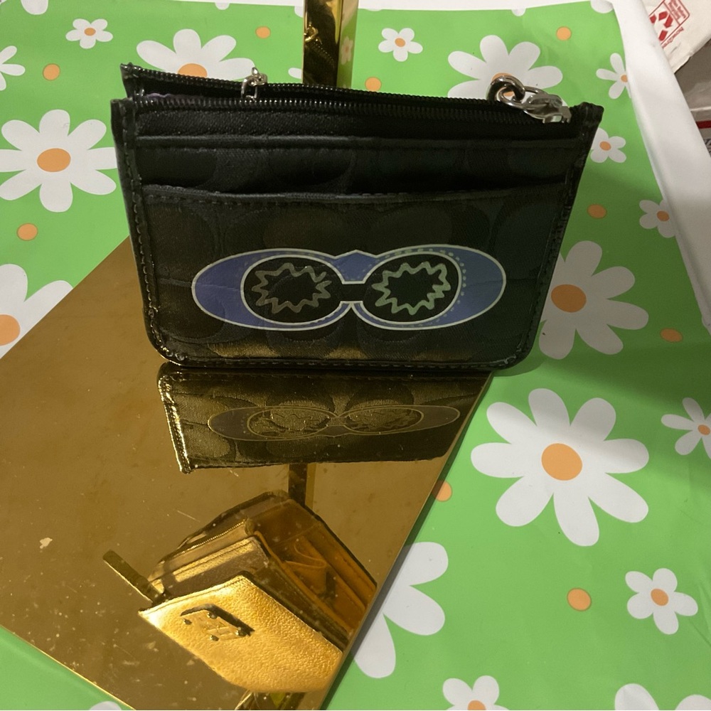 The Coach Poppy cardholder wristlet comes with an unbranded strap.